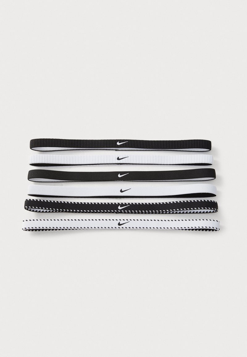 Set of five elastic hair ties in black and white. Features Nike logo; textured design on black ties, and white ties with a contrasting pattern.