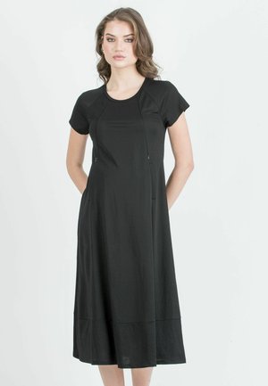 Zwarte midi-jurk met korte mouwen, ronde halslijn en twee zijzakken. Gemaakt van een soepel materiaal en heeft een lichte A-lijn silhouet.