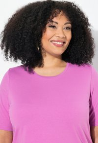 Maglietta a maniche corte con colletto a girocollo in tessuto rosa brillante, caratterizzata da una superficie liscia e una vestibilità comoda, ideale per l'abbigliamento casual.