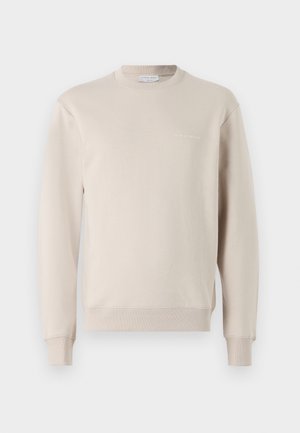 Beige genser laget av en bomullsblanding, med rund hals, lange ermer, ribbestrikkede mansjetter og en subtil logo trykt nær brystet.