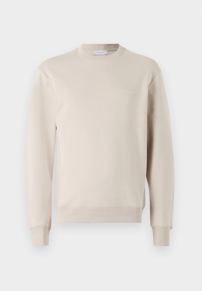 Sweatshirt bege feito de uma mistura de algodão, com gola redonda, mangas longas, punhos canelados e um logotipo discreto impresso perto do peito.