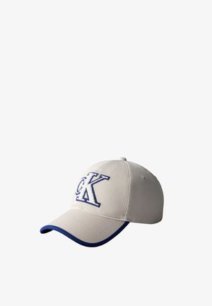 Beżowa czapka bejsbolowa z niebieską lamówką na daszku i wyhaftowanym niebieskim logo "CK" na przednim panelu.