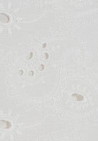 Tissu blanc brodé présentant des motifs paisley complexes, une surface texturée et de petits détails découpés, créant une apparence délicate.