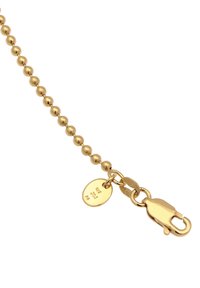 Goldene Kugelketten mit runden Perlen, einem Karabinerverschluss und einem kleinen ovalen Anhänger mit gravierten Details. Glatte Textur über die gesamte Kette.