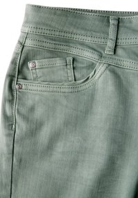 Jeans de mezclilla verdes con un bolsillo frontal, acentos de hardware plateado y costuras en contraste a lo largo de las costuras. Textura suave y forma ajustada.