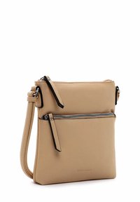 Beige kožená taška přes rameno s přední kapsou na zip, nastavitelným popruhem a černými zipovými akcenty. Hladký povrch a minimalistický design.