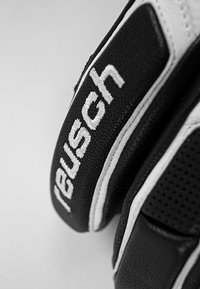 Guanti da portiere in bianco e nero con materiale sintetico testurizzato, impugnatura imbottita e cuciture bianche a contrasto con il logo "Reusch".