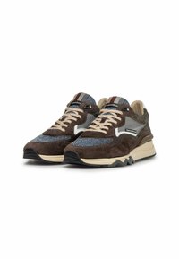Sneaker in suede marrone e tessuto con tomaia in rete testurizzata, intersuola crema e suola esterna in gomma nera. Presenta lacci beige e una linguetta con motivo.