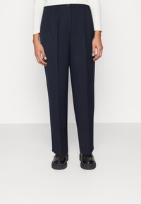 Pantaloni larghi in navy scuro con design plissettato, realizzati in un tessuto leggero. Presentano una chiusura con bottone frontale e passanti per cintura.