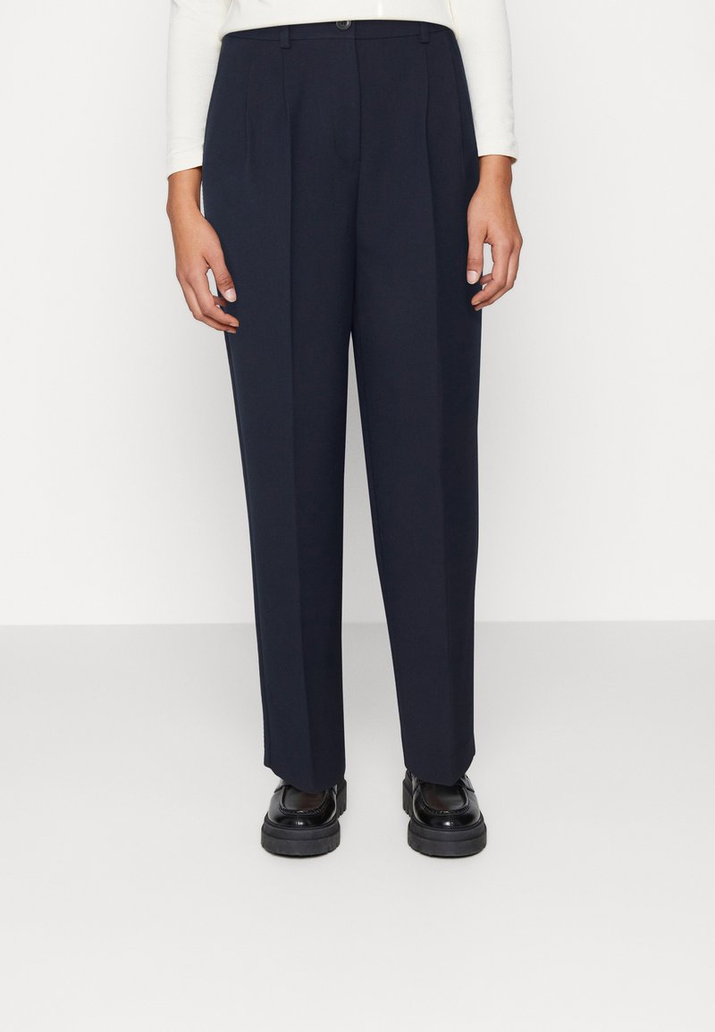 Pantaloni larghi in navy scuro con design plissettato, realizzati in un tessuto leggero. Presentano una chiusura con bottone frontale e passanti per cintura.