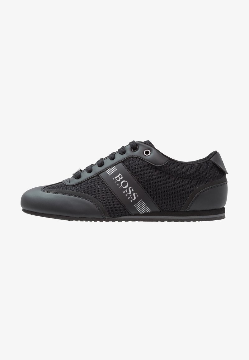 Black athletic shoe featuring a mix of smooth synthetic leather and breathable fabric, with a logo accent and traditional lace-up design.