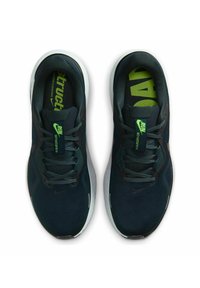 Zapatillas deportivas de color azul oscuro con parte superior de malla texturizada y transpirable, acentos verdes y suela blanca. Presentan cordones planos y plantillas acolchadas.