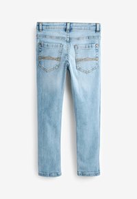 Jean en denim bleu clair vu de dos avec deux poches présentant des motifs de couture horizontaux et des passants de ceinture le long de la ceinture.