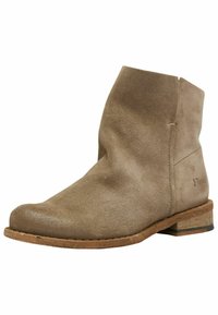 Stivaletto in suede beige con punta rotonda, tacco basso in legno e cuciture minime. La parte superiore presenta una texture liscia e un design casual.