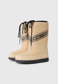 Botas acolchoadas em bege com atacadores pretos e uma faixa com logotipo. Apresentam uma sola e costura em preto contrastante, proporcionando uma silhueta estruturada.