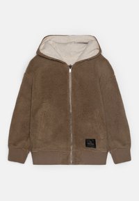 Felpa marrone in pile con chiusura a zip, interno crema, orlo e polsini a costine, e un'etichetta nera sul davanti.