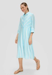 Hellesblau gestreiftes Kleid mit Kragen, Dreiviertelärmeln und Knopfleiste. Verfügt über eine fließende Silhouette und weichen Stoff.