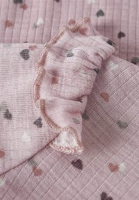 Rosa strukturiertes Gewebe mit einem gerippten Design, das kleine bunte Herzen und einen welligen Rand aufweist. Weiches Material mit einer zarten Ausführung.