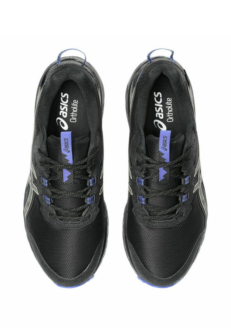 Zapatillas deportivas negras con parte superior de malla, acentos púrpuras en contraste y logo plateado metálico. Presentan cordones planos y una suela texturizada.