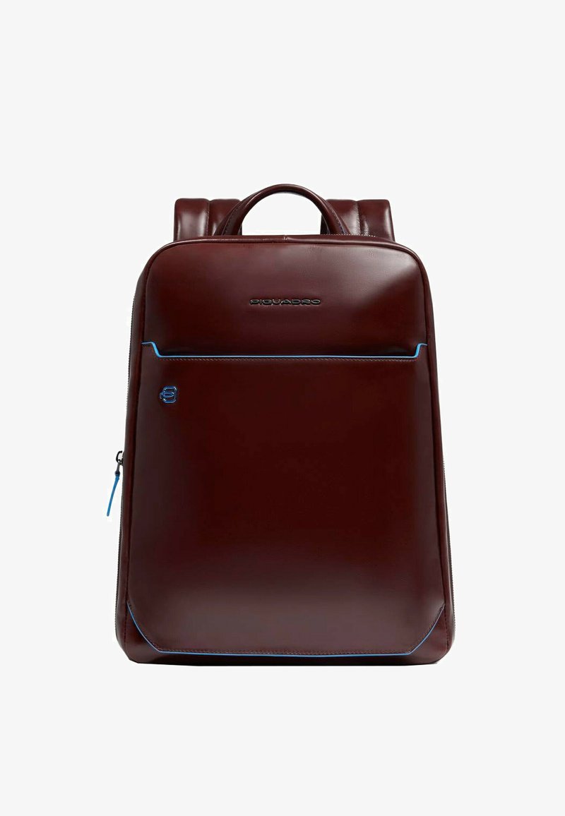 Zaino in pelle marrone scuro dalla texture liscia, con dettagli blu e una tasca frontale con cerniera. Progettato con doppi spallacci e una maniglia superiore.