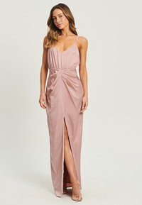 Pink satin evening dress with a deep v-neck, adjustable straps, and a side slit. The fabric has a smooth texture and gathered waist detailing.