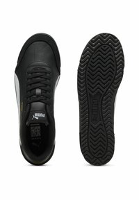 Baskets en cuir noir avec une bande blanche, dotées d'une semelle en caoutchouc texturé et de lacets ronds. Accentuées par un logo doré sur le côté.