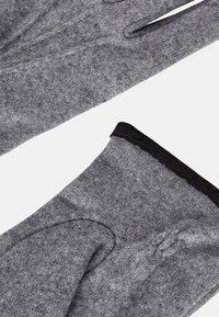 Grå stickade handskar gjorda av mjukt, varmt material, med en slät yta, design med tre fingrar och svart kant vid handleden.