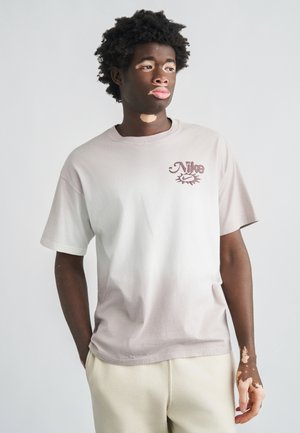 Lysegrå bomulds-T-shirt med en burgunder Nike-logo på brystet, korte ærmer og en afslappet pasform.