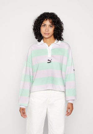 Lichtgewicht, cropped polo trui in pastelstrepen van muntgroen en lavendel. Heeft een witte kraag en een zwart Puma-logo op de borst.