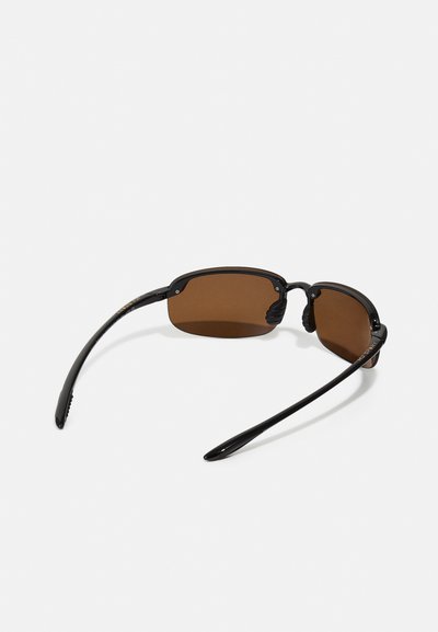 Occhiali da sole con montatura in plastica nera, lenti brune e bracci curvi. Presentano un design aerodinamico con accenti testurizzati sulle tempie.