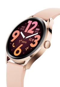 Smartwatch met een ronde wijzerplaat, roségouden behuizing en een roze siliconen band. Het display toont vetgedrukte cijfers in oranje en roze op een donkere achtergrond.