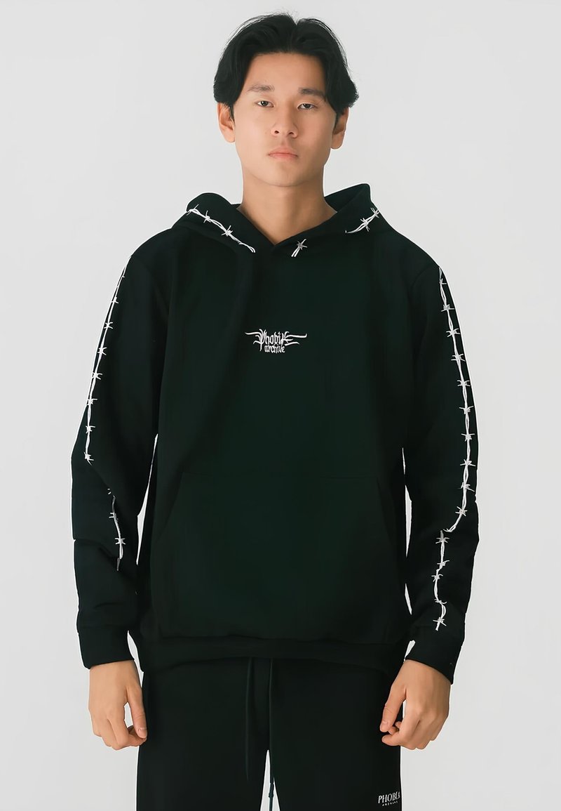 Felpa nera con cappuccio e tasca a marsupio, design con filo spinato lungo le maniche e un piccolo logo sul petto. Materiale morbido e vestibilità comoda.