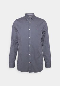 Camicia button-up blu navy con pois bianchi, dotata di un colletto classico, maniche lunghe e un dettaglio con logo sul petto.