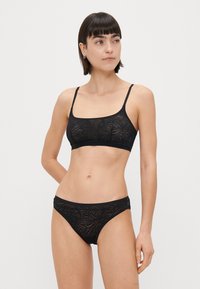 Μαύρο δαντελένιο μπραλέτ με γεωμετρικό μοτίβο, με λεπτές τιράντες και φαρδύ λάστιχο. Ιδανικό μαύρο δαντελένιο μπικίνι με παρόμοιο σχέδιο.