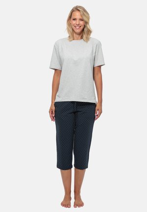 Grå t-shirt med kort ärm i kombination med marinblå capribyxor med prickar. I bomullsmaterial, lös passform och rund halsringning. Ingen synlig utrustning.