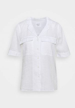 Chemise en lin blanc, manches courtes, col, deux poches poitrine, fermeture à boutons, tissu légèrement texturé, et coupe décontractée.