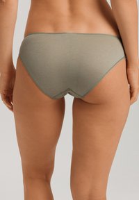 Gröna bikiniunderdelar i bomullsblandning med en mjuk textur, låg midja och kontrasterande sömmar längs kanterna.