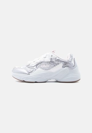 Ezüst és fehér sportcipő, texturált, fényes felsőrésszel, lekerekített orral és párnázott fehér talppal. A fűzők megerősített fülön vannak átfűzve.