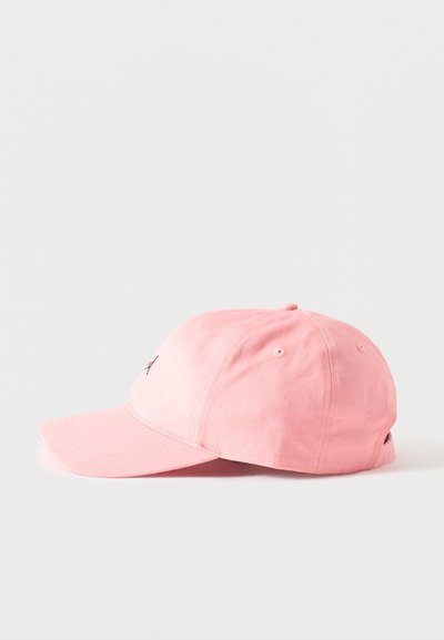 Casquette de baseball en coton rose avec une visière courbée et un logo brodé à l'avant, vue de côté sur fond blanc.