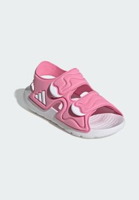 Różowa sportowa sandał z formowanym kształtem, trzema regulowanymi paskami oraz białą gumową podeszwą z teksturowanym bieżnikiem.