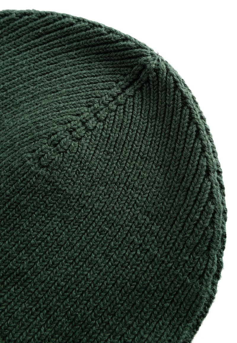 Groene gebreide beanie met een gladde, textuurrijke oppervlakte en spiraalribben. De afgeronde bovenkant is afgewerkt met een nette naad.