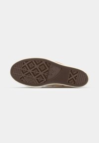 Brun gummisåle med teksturerte geometriske mønstre, omkranset av en beige kant. Inkluderer et logoavtrykk og har et flatt design.