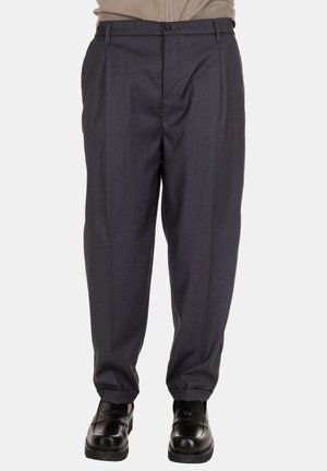 Pantaloni grigi su misura con fronte piatto, pieghe e design a gamba dritta. Il tessuto ha una consistenza liscia; la vita presenta una chiusura con bottone.