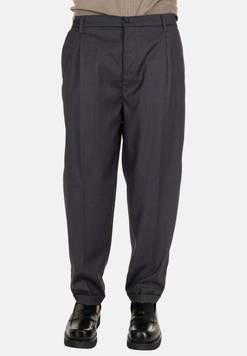 Pantaloni grigi su misura con fronte piatto, pieghe e design a gamba dritta. Il tessuto ha una consistenza liscia; la vita presenta una chiusura con bottone.