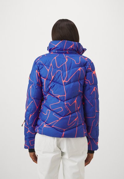 Blaue Pufferjacke mit einem geometrischen pinken Muster. Verfügt über einen hohen Kragen und eine gesteppten Textur, entworfen für Isolierung und Wärme.