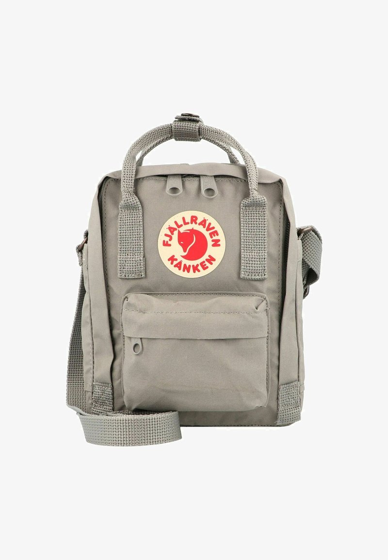 Gray Fjällräven Kånken bag with top handle, adjustable shoulder strap, front pocket, and red circular logo on beige background. Durable material.