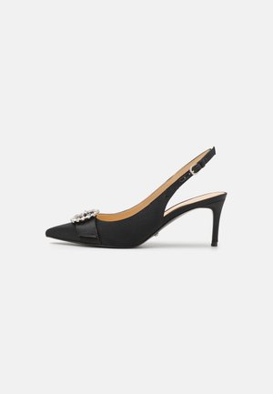 Décolleté slingback nera in satin con punta appuntita, tacco a stiletto di altezza media, dettaglio decorativo con fibbia in argento e cinturino alla caviglia regolabile.