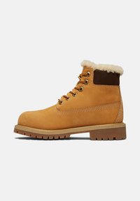 Helle Leder-Ankle-Boots mit Kunstfellkragen, braunen Wildlederakzenten und gelben Schnürsenkeln. Sie verfügen über eine strukturierte Gummisohle mit tiefen Profilen.