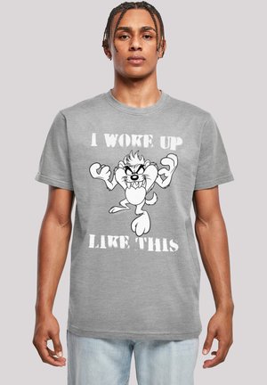 Graues Baumwoll-T-Shirt mit einem Cartoon-Charakter, der die Arme hochgehoben hat, und dem Satz "ICH BIN SO AUFGEWACHT" in fettgedrucktem weißen Text.