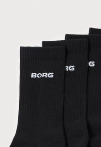 Μαύρες κάλτσες με ριμπ υφή, με λευκό λογότυπο «BORG» υφασμένο κοντά στο πάνω μέρος. Τέσσερα ζεύγη στοιβαγμένα με μικρή επικάλυψη.